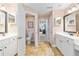 Bathroom with dual vanities, and toilet; hallway with a view to the Gathering room and entry to bedroom at 12495 Sw 66Th St, Ocala, FL 34481