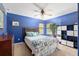 Bright blue bedroom featuring a queen bed, ceiling fan, and windows providing ample natural light at 12495 Sw 66Th St, Ocala, FL 34481