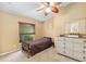 Comfortable bedroom with ceiling fan, dresser, small bed, and a big window with privacy blinds at 12495 Sw 66Th St, Ocala, FL 34481