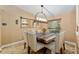 Cozy dining room features a rustic table, upholstered chairs, and elegant lighting at 12495 Sw 66Th St, Ocala, FL 34481