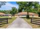 Home exterior with a long driveway leading to a detached garage, backyard pool, and mature trees offering shade at 12495 Sw 66Th St, Ocala, FL 34481