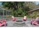 Outdoor fire pit featuring seating, mature trees, and views of the screened in pool, great for evening relaxation at 12495 Sw 66Th St, Ocala, FL 34481