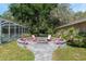 Outdoor fire pit area with chairs for gathering, set near a screened-in pool area at 12495 Sw 66Th St, Ocala, FL 34481