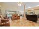 Open living area with travertine floors, comfortable seating, and views of the pool area at 12495 Sw 66Th St, Ocala, FL 34481