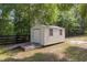 Durable backyard storage shed with wooden ramp nestled amid lush trees and a fenced yard at 12495 Sw 66Th St, Ocala, FL 34481