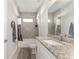 Bathroom features a granite countertop vanity, tub with shower, and neutral decor at 14055 Sw 30Th Terrace Rd, Ocala, FL 34473