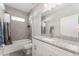 Bathroom features a granite countertop vanity, tub with shower, and neutral decor at 14055 Sw 30Th Terrace Rd, Ocala, FL 34473