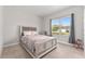 Bedroom featuring a bed with a floral comforter, large window, and neutral decor at 14055 Sw 30Th Terrace Rd, Ocala, FL 34473
