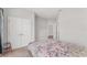 Bright bedroom with gray walls, carpeted floors, and a gray and pink floral comforter at 14055 Sw 30Th Terrace Rd, Ocala, FL 34473
