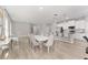 Open floor plan with dining area, white kitchen, and a breakfast bar with modern pendant lighting at 14055 Sw 30Th Terrace Rd, Ocala, FL 34473