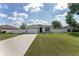 Charming single-story home with a well-manicured lawn, long driveway and white perimeter fence at 14055 Sw 30Th Terrace Rd, Ocala, FL 34473