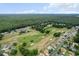 Aerial view showcasing the neighborhood, featuring a golf course, tree-lined streets, and community amenities at 14481 Sw 112Th Cir, Dunnellon, FL 34432