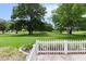 Beautiful backyard view overlooking expansive green space, enhanced with a charming white picket fence at 14481 Sw 112Th Cir, Dunnellon, FL 34432