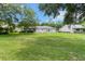 Spacious backyard with green lawn surrounded by trees, and an expansive rear elevation at 14481 Sw 112Th Cir, Dunnellon, FL 34432