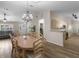 Inviting dining room with wood-look flooring, table with seating for six, open floor plan to living room and kitchen at 14481 Sw 112Th Cir, Dunnellon, FL 34432