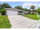 Single Gathering home featuring an attached garage, well-maintained driveway, and lush landscaping at 14481 Sw 112Th Cir, Dunnellon, FL 34432