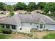 Back exterior view featuring a cozy patio, complemented by manicured landscaping and mature trees at 14481 Sw 112Th Cir, Dunnellon, FL 34432