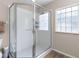 Shower stall with glass door and tiled walls, featuring a window for natural light at 14481 Sw 112Th Cir, Dunnellon, FL 34432