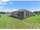 Home exterior featuring a screened lanai, green lawn, and partial fencing at 16192 Se 104Th Ter, Summerfield, FL 34491