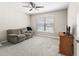 Cozy bedroom featuring a ceiling fan, neutral paint, and a large window offering natural light at 16192 Se 104Th Ter, Summerfield, FL 34491
