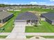 New construction home boasts gray tones, a modern landscape, and a well-maintained lawn in a suburban neighborhood at 16192 Se 104Th Ter, Summerfield, FL 34491
