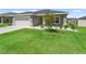 Well-maintained lawn and landscaped garden accent this gray home, complete with a two-car garage for convenience at 16192 Se 104Th Ter, Summerfield, FL 34491