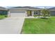Charming home featuring a gray exterior, well-manicured lawn, and a bright yellow front door for a cheerful welcome at 16192 Se 104Th Ter, Summerfield, FL 34491