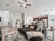 Open-concept living room and kitchen features a ceiling fan and a comfortable sectional sofa at 16192 Se 104Th Ter, Summerfield, FL 34491