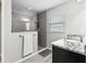 Modern bathroom with a glass shower, gray tiling, and a granite countertop sink at 16192 Se 104Th Ter, Summerfield, FL 34491