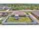 Expansive aerial view of the fenced backyard, screened patio, landscaping, and surrounding properties at 16969 Sw 40Th Cir, Ocala, FL 34473
