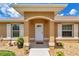 Charming front entrance with a covered porch, decorative shrubbery and manicured landscaping at 16969 Sw 40Th Cir, Ocala, FL 34473