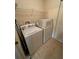 Practical laundry room with washer, dryer, and overhead shelving for storage at 24 Malauka Ter, Ocklawaha, FL 32179