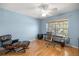 Light-blue bedroom features a ceiling fan, wood-look floors, and a large window at 4225 Sw 57Th Ave, Ocala, FL 34474