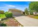 Single-story home with a well-manicured lawn, two car garage, and inviting walkway at 4225 Sw 57Th Ave, Ocala, FL 34474