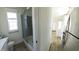 Bright bathroom featuring a glass-enclosed shower, white fixtures, and a connecting view to the kitchen at 4345 Nw 27Th Pl, Ocala, FL 34482