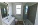 Bathroom with white vanity, tile shower, and a window at 4345 Nw 27Th Pl, Ocala, FL 34482