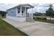 Stylish single-story park model with a covered porch and concrete parking pad at 4345 Nw 27Th Pl, Ocala, FL 34482