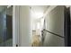 Modern interior showcasing a stainless steel refrigerator, wood flooring, and a view to a bathroom with glass shower at 4345 Nw 27Th Pl, Ocala, FL 34482