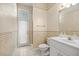 Cozy bathroom featuring a toilet, vanity with sink, and a glass enclosed shower/tub with exterior access at 4812 Se 12Th Pl, Ocala, FL 34471