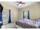 Bedroom with a plaid comforter, ceiling fan, and blue curtains at 4812 Se 12Th Pl, Ocala, FL 34471
