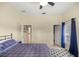 Bedroom featuring a plaid comforter, ceiling fan, and direct access to the bathroom and closet at 4812 Se 12Th Pl, Ocala, FL 34471