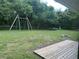 Spacious backyard featuring a swing set, trampoline, fire pit, and deck at 4911 Se 135Th Pl, Summerfield, FL 34491