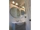 Bathroom features updated vanity, lighting, and a round mirror at 4911 Se 135Th Pl, Summerfield, FL 34491