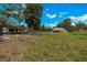 Spacious grassy backyard with a clear view of the house, a camper, and surrounding trees under a bright sky at 531 Ne 142Nd Ave, Silver Springs, FL 34488