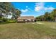 Exterior view of a cozy home with a well-maintained lawn, clear skies, and an umbrella-shaded seating area at 531 Ne 142Nd Ave, Silver Springs, FL 34488