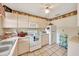 Efficient kitchen design features white cabinets, tiled floor, and essential appliances for cooking and storage at 531 Ne 142Nd Ave, Silver Springs, FL 34488