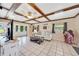 Cozy living room featuring a beamed ceiling, neutral decor, and access to an outdoor deck at 531 Ne 142Nd Ave, Silver Springs, FL 34488