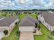 An elevated shot showcases a well-manicured home with a gray roof, lush landscaping, and vibrant green lawns at 6051 Sw 93Rd Cir, Ocala, FL 34481