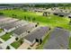 Wide aerial shot exhibits a neighborhood with manicured lawns and houses, with green spaces stretching into the distance at 6051 Sw 93Rd Cir, Ocala, FL 34481