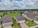Community aerial view showcases home in landscaped neighborhood with green spaces, surrounded by blue skies and scattered clouds at 6051 Sw 93Rd Cir, Ocala, FL 34481